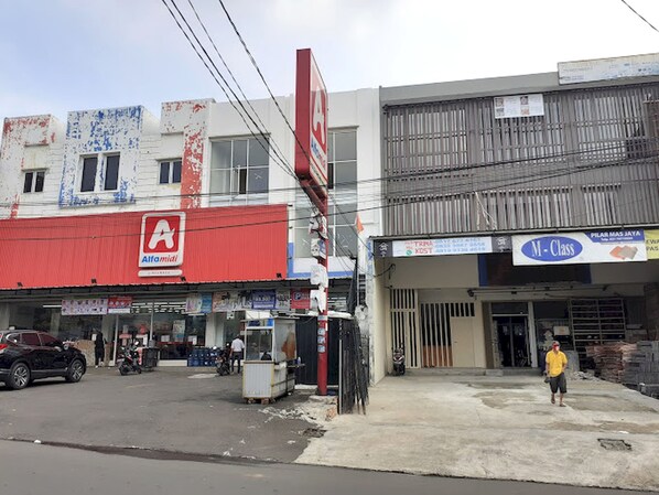 Vista da rua com uma fachada vermelha identificada como 