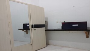 Une pièce comprenant une grande armoire, un bureau et une chaise.