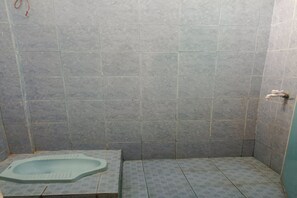 Eenvoudige tweepersoonskamer | Badkamer | Een douche, handdoeken, zeep