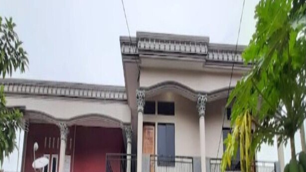 Un bâtiment à deux étages doté d’un balcon, d’une entrée couverte et d’une enseigne sur le mur.