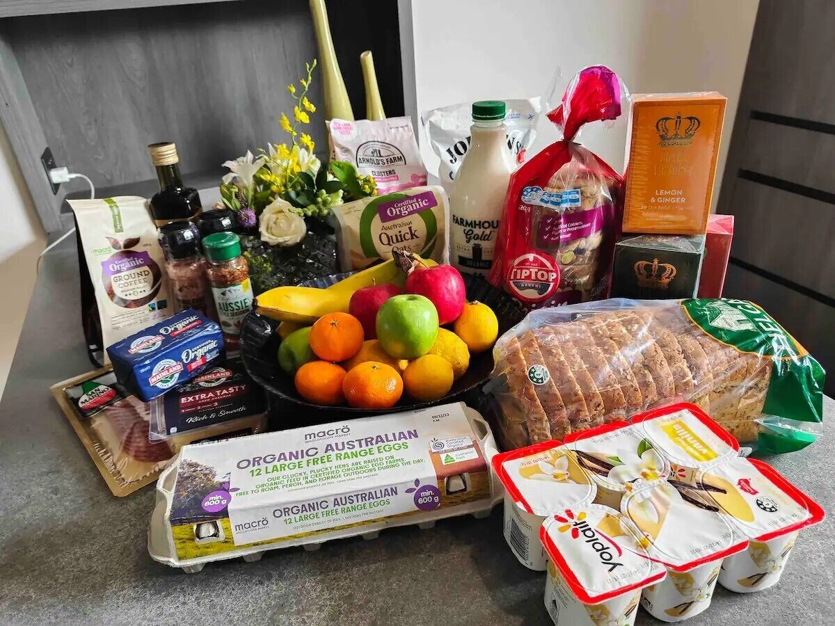 A variety of food items including eggs, bread, and fruits on a kitchen counter.