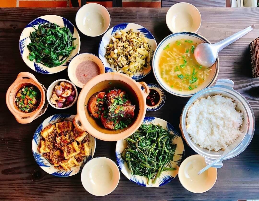 A variety of dishes including a bowl of soup, a plate of rice, and several side dishes.