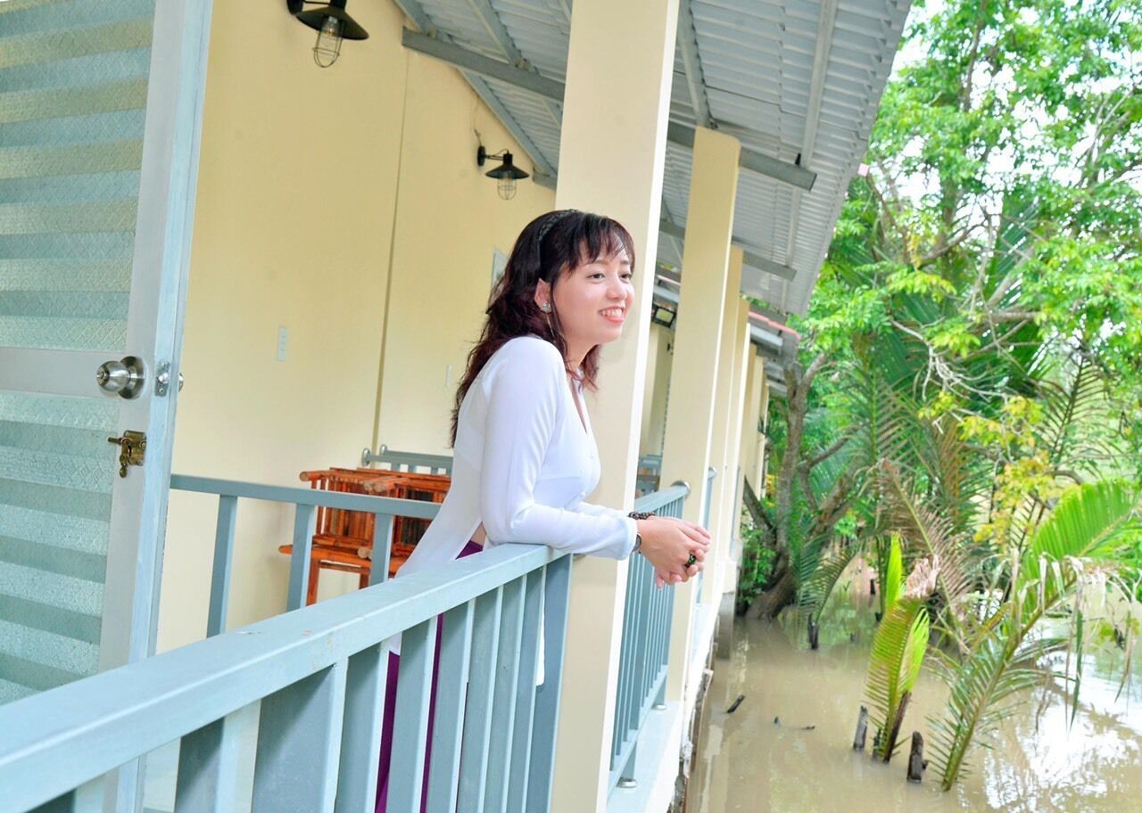 A balcony with a railing, a wooden chair, and a table.