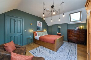 A bedroom with a bed, dresser, and a window.