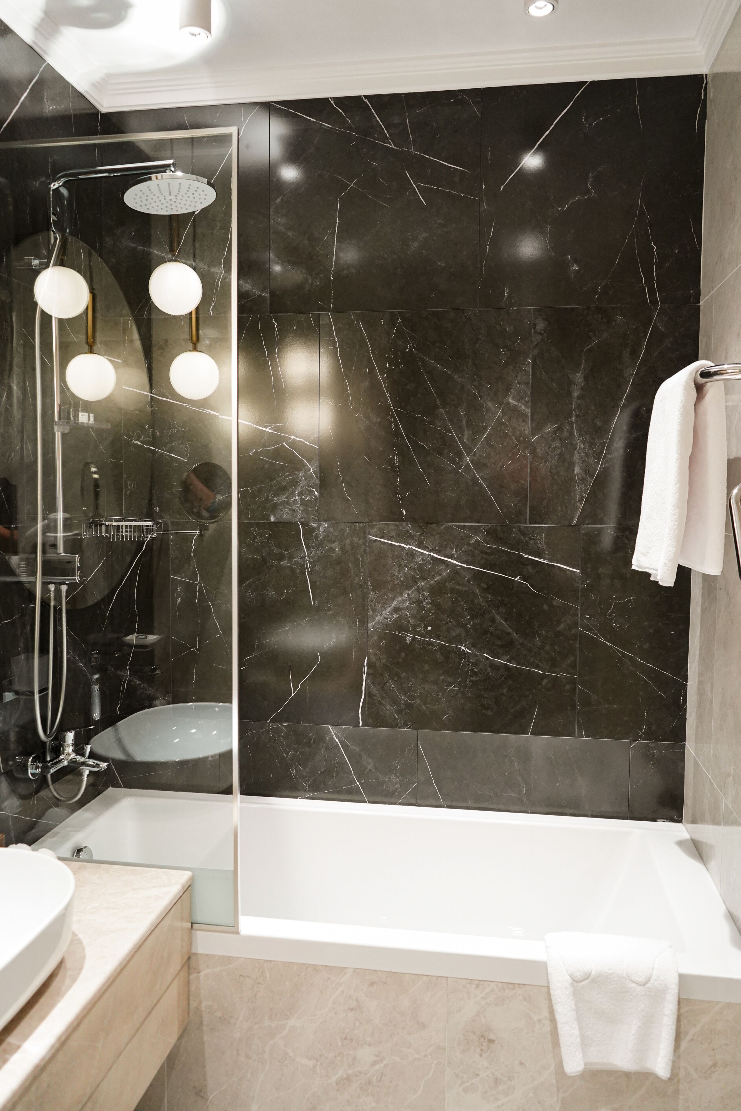 Une salle de bain moderne dotée d’une douche à parois de verre, d’une baignoire et d’un meuble-lavabo avec un évier.