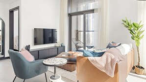 A modern living room with a sofa, armchair, coffee table, and a large window. - Silkhaus 15 Northside, Business Bay Dubai (Dubai)