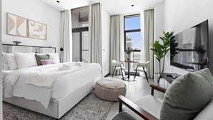 A modern hotel room with a large bed, a seating area with a table, and a TV. - Silkhaus 15 Northside, Business Bay Dubai (Dubai)