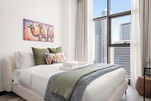 A modern hotel room with a large bed, a city view, and a colorful artwork on the wall. - Silkhaus 15 Northside, Business Bay Dubai (Dubai)