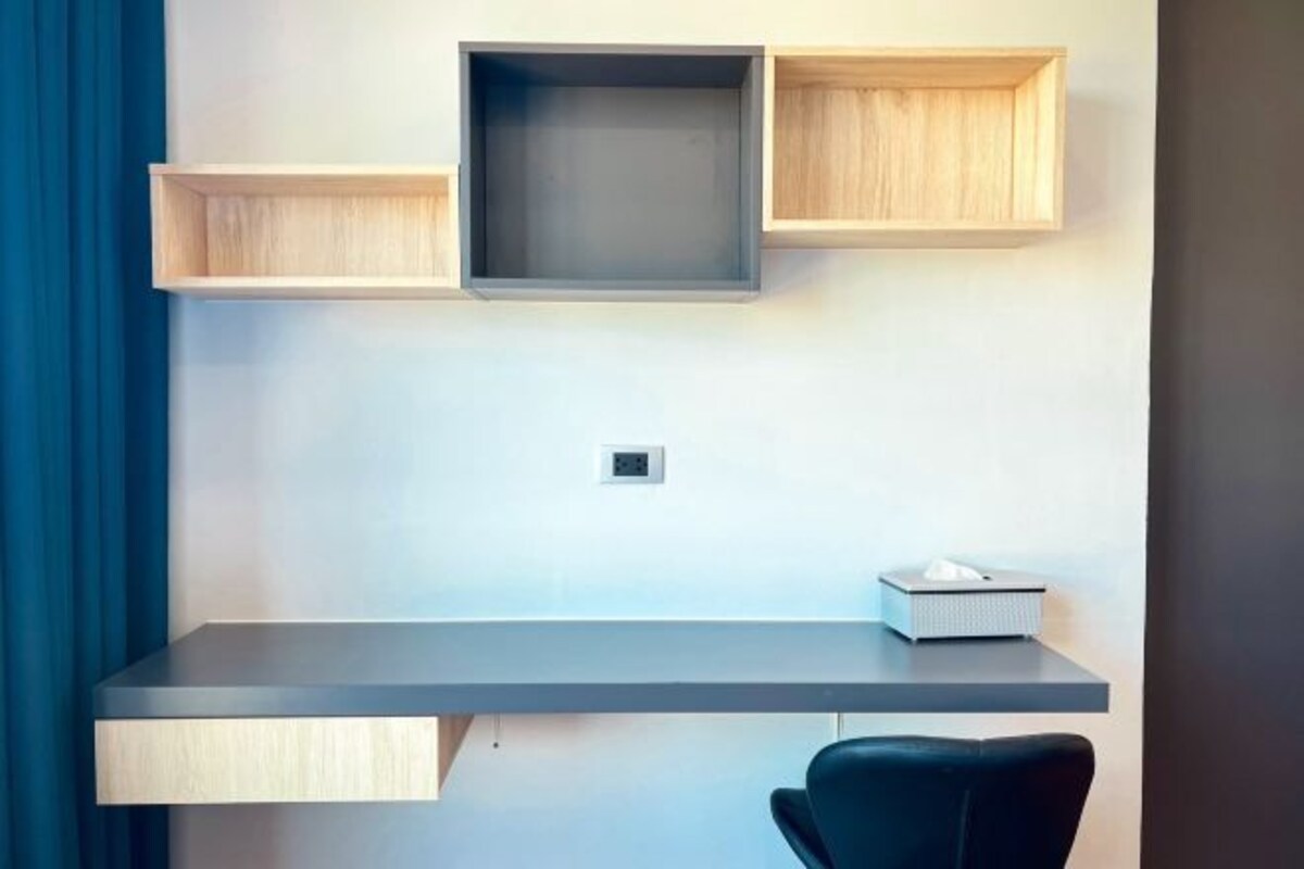 A modern office space with a desk, a chair, and three shelves.