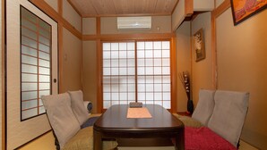 Ett traditionellt japanskt rum med tatamimattor på golvet, ett lågt träbord och skjutbara shojidörrar.