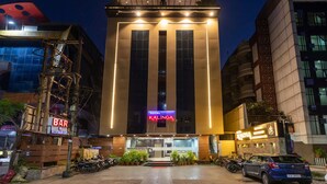 A hotel named Kalinga with a modern facade, large windows, and a neon sign. - HOTEL KALINGA (Indore)