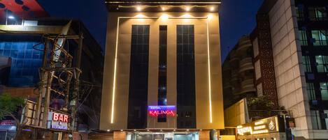 Un hotel llamado Kalinga con una fachada moderna, ventanas grandes y un letrero de neón.