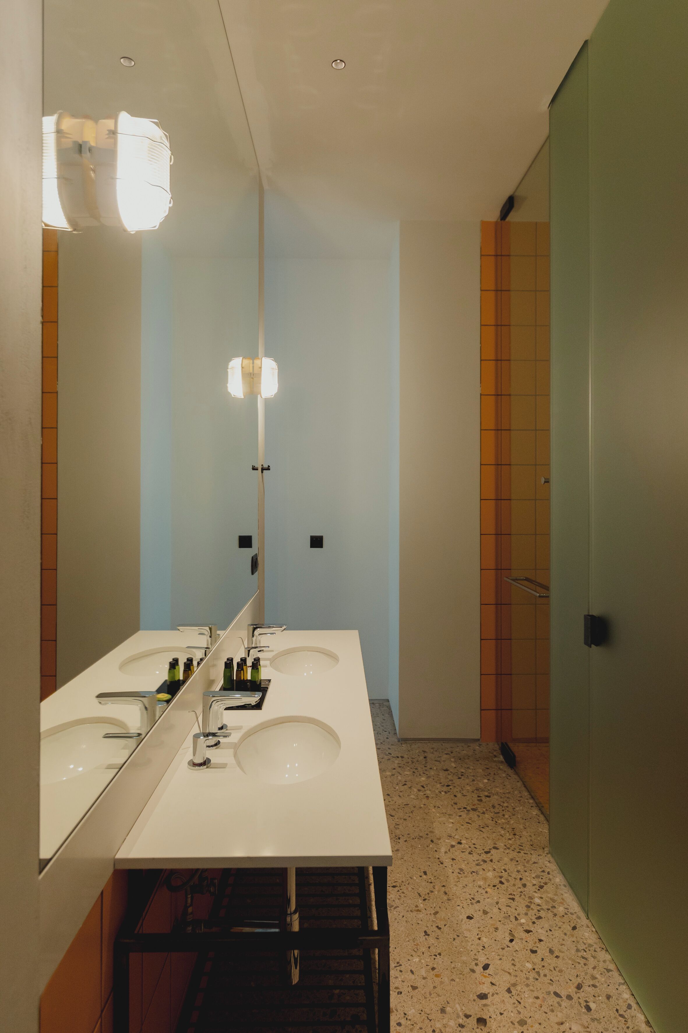 A modern bathroom with two sinks, a large mirror, and a shower area.
