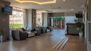 A hotel lobby with a reception desk, seating area, and a view of the outside. - Valhalla Pattaya Hotel (Pattaya)