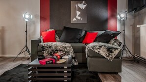 Un salon moderne comprenant un ensemble de canapés, une table basse avec des livres et une boîte, ainsi que deux lampadaires.