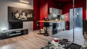 Un salon moderne doté d’un téléviseur à écran plat, d’un coin repas et d’une cuisine.