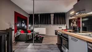 Un espace de vie compact comprenant un coin cuisine, un coin repas et un coin salon avec un canapé et une table basse.