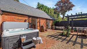 A hot tub outside a brick building with a pergola and garden. - The Willows -  a holiday let by Bloom Stays that sleeps 8 guests  in 4 bedrooms (Ash)