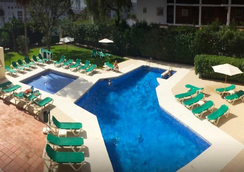 A pool area with multiple pools and sun loungers.