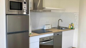 Une cuisine moderne équipée d’un réfrigérateur en acier inoxydable, d’un four à micro-ondes encastré et d’un grille-pain.
