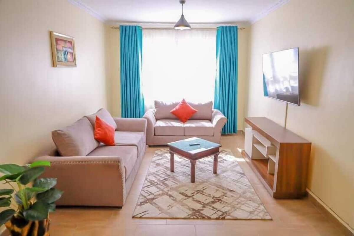A living room with two sofas, a coffee table, a TV, and a TV stand.