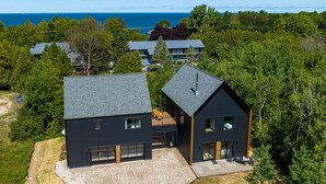 A modern two-story house with a large driveway and a view of the sea. - 6BR Designer Retreat · Walk to Downtown Egg Harbor (Egg Harbor)
