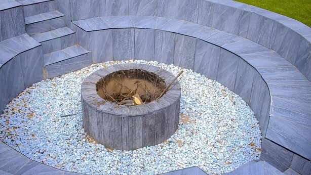 A circular stone fire pit with steps leading up to it, surrounded by pebbles. - Semeni Asante Getaway (Johannesburg South)