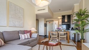 A modern living room with a sofa, coffee table, and a dining area with chairs and a table.