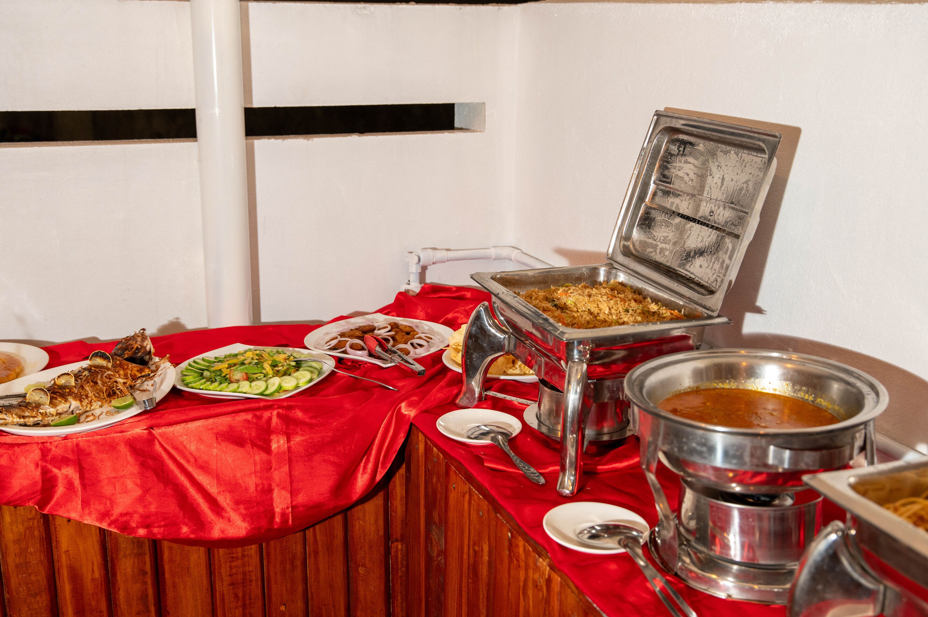 A buffet table with various dishes and a hot pot.