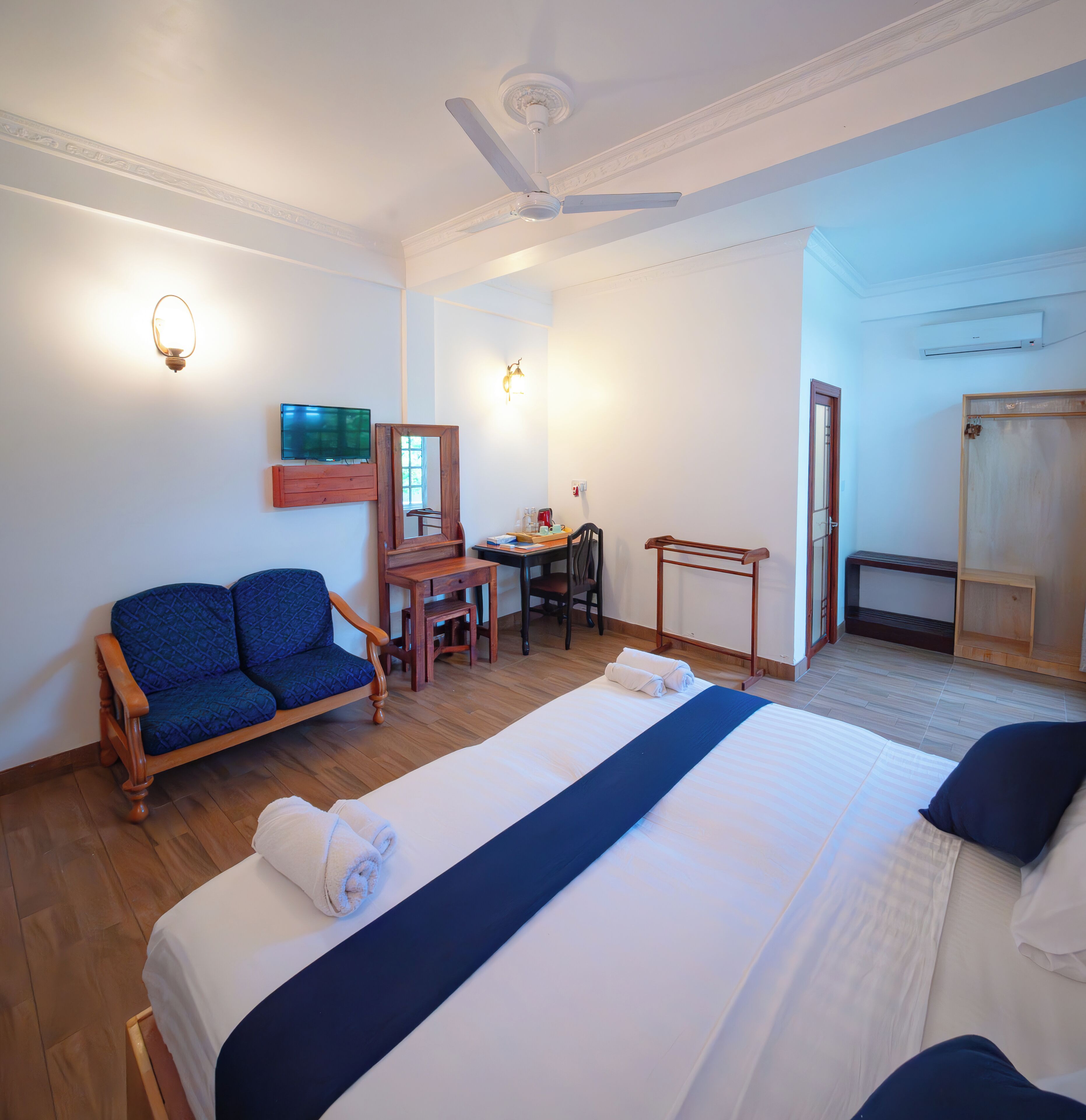 Une chambre d’hôtel comprenant un lit, un canapé, un bureau, une chaise et une armoire.