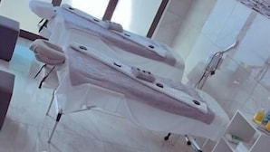 Une salle d’examen médical équipée de deux tables d’examen, d’un comptoir d’accueil et d’une fenêtre avec des stores.