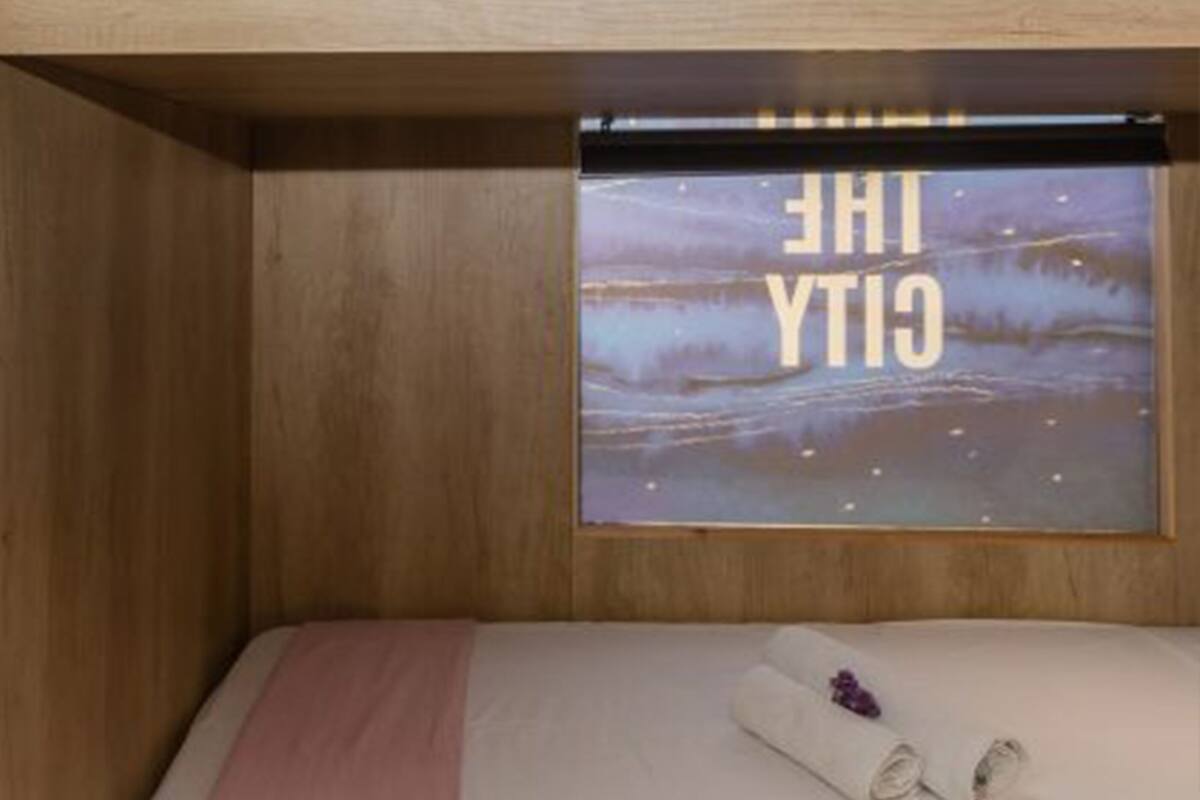 A bunk bed with a view of the ocean through a window.