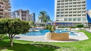 A modern urban area with a large swimming pool, surrounded by well-maintained grass and trees. - Stunning views over the sea + parking. TOP (Calpe)