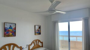 A hotel room with two beds, a ceiling fan, and a balcony with a view of the sea. - Stunning views over the sea + parking. TOP (Calpe)