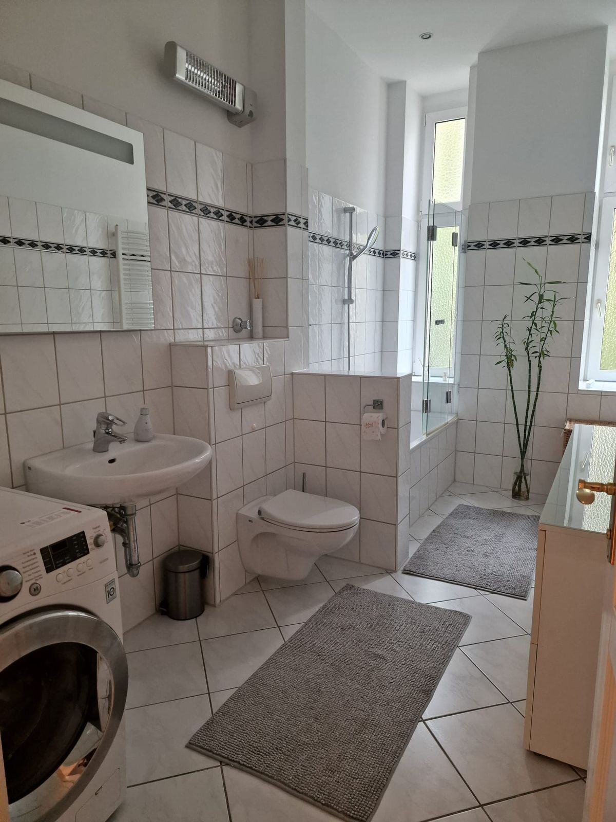 Un baño moderno con lavamanos, inodoro y lavadora.