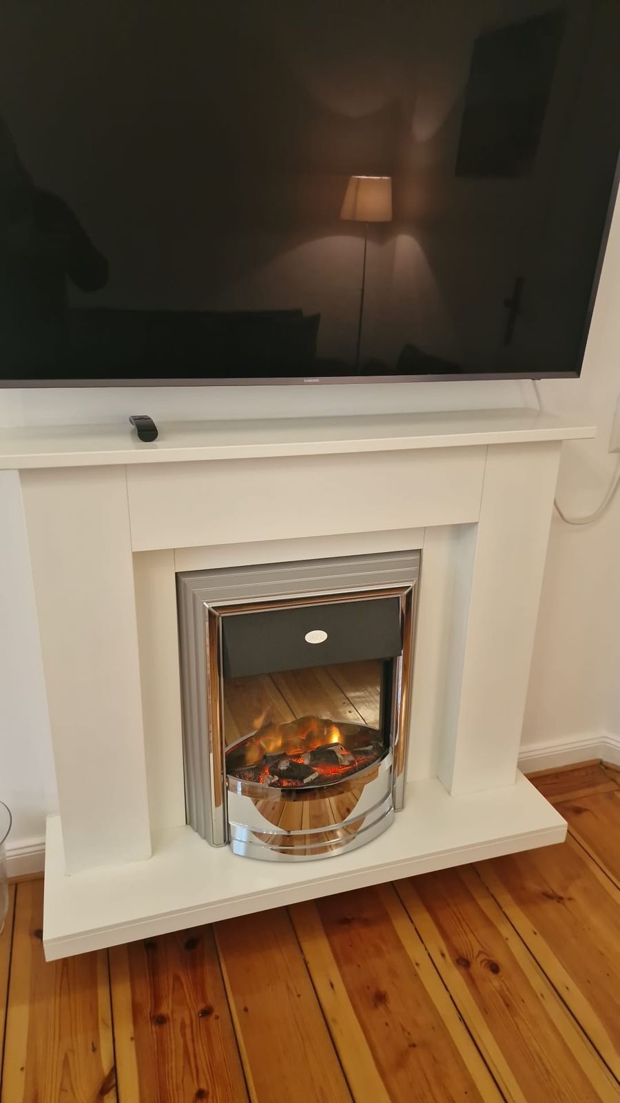 A modern fireplace with a flat-screen TV mounted above it.