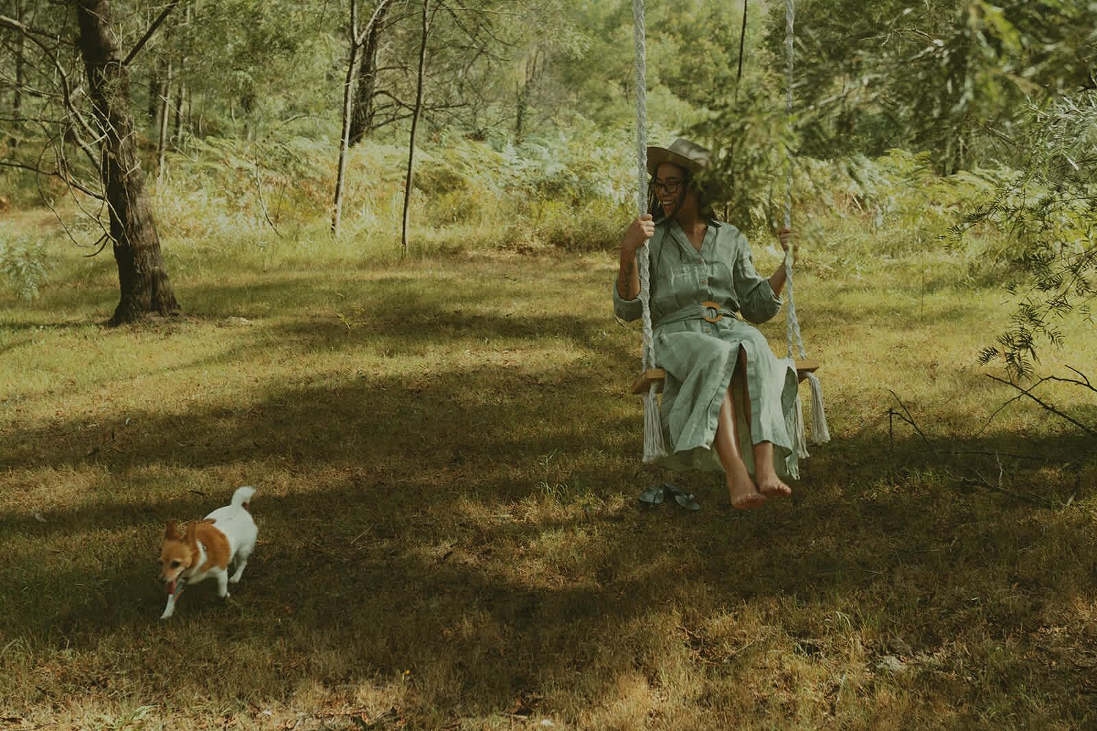 A person sitting on a swing in a wooded area.
