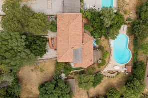 An aerial view of a property with a swimming pool, a large house with a tiled roof, and surrounding greenery. - Villa Vì con piscina by Wonderful Italy (Arzachena)