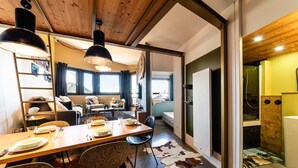 Ein modernes Interieur mit Essbereich, einer Couch und Blick auf einen Berg.