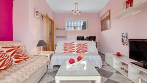 A modern bedroom with a bed, a TV, a coffee table, and a desk. - Sol Montemar 23 - Swimming Pool, Parking, 200m from the beach (Torremolinos)