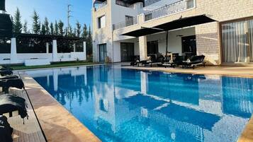 15 outdoor pools, open 8:00 AM to 8:00 PM, pool umbrellas, pool loungers