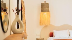 A bedroom with a bed, bedside table, and a chair. - Cavanna Lodge (Ounagha)