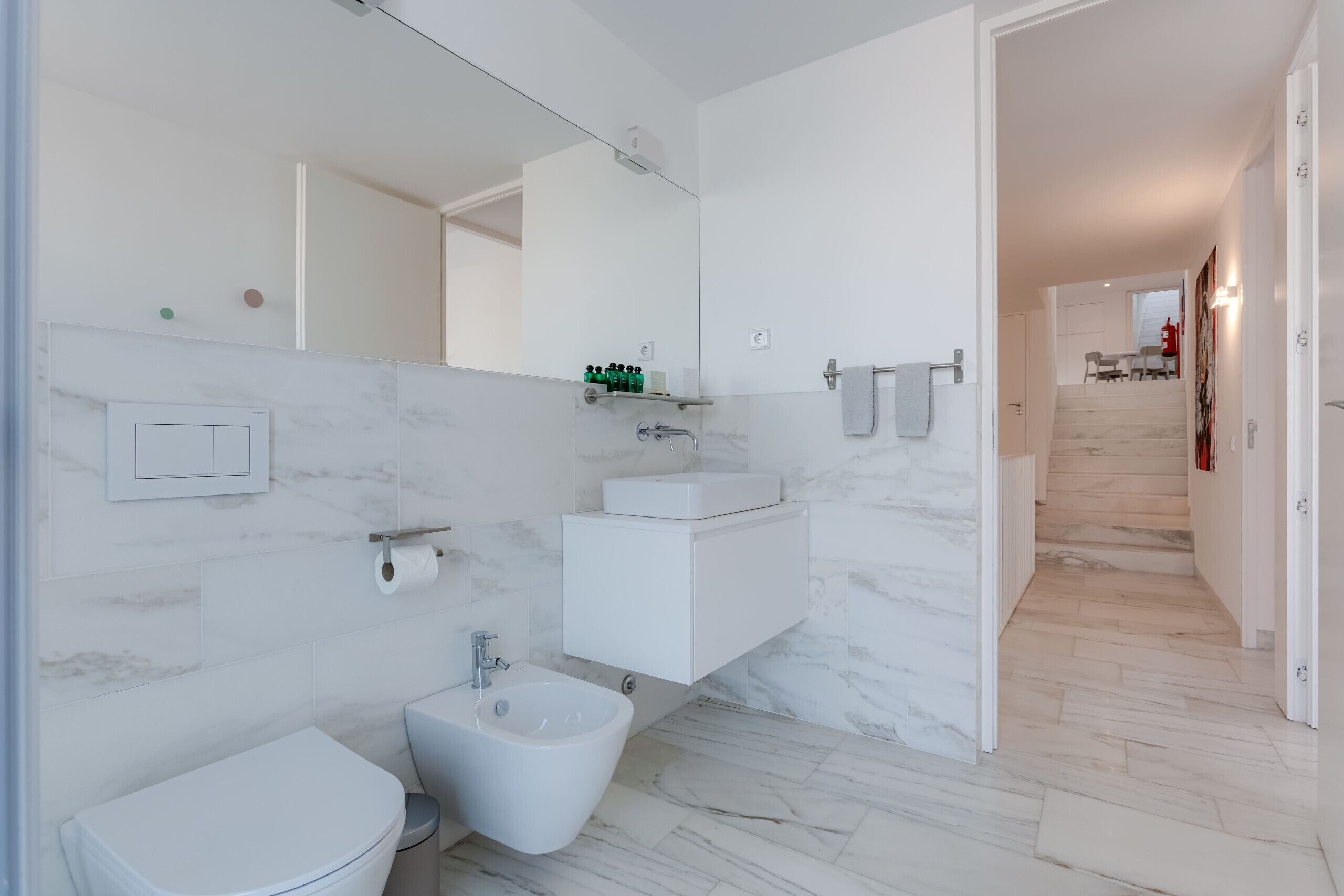 Ein modernes Badezimmer mit Toilette, Bidet und Waschbecken.