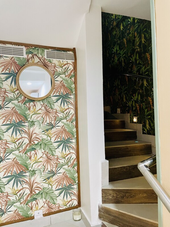Eine Treppe mit Holzwurf und einer Wand mit tropischem Blattmuster.