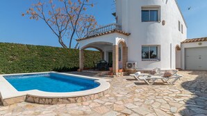 A two-story house with a swimming pool, stone patio, and a tree with autumn leaves. - Beachside Haven with Pool, BBQ, WiFi & A/C – 200m from Sant Pere Pescador Beach (Sant Pere Pescador)