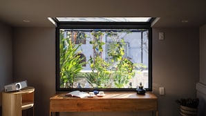Ein Zimmer mit Oberlichter, einem Holztisch mit einem Buch, zwei Tassen und einem Projektor.