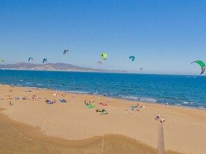 A beach with people, tents, and kites.