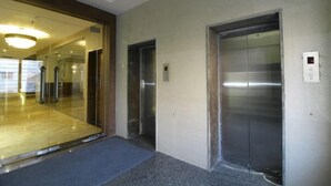 A modern elevator area with glass doors and a digital display. - Sindhura Grand (Hyderabad)