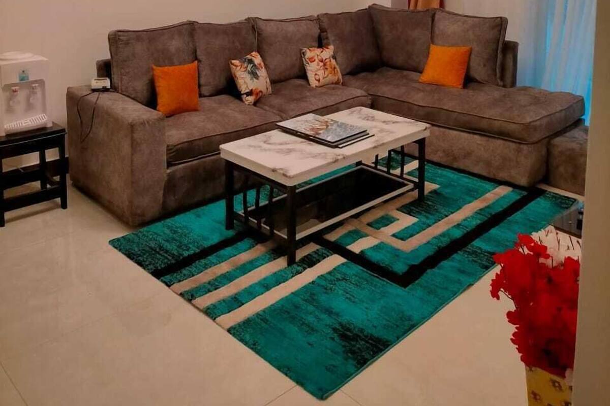 A living room with a sectional sofa, a coffee table, and a rug.