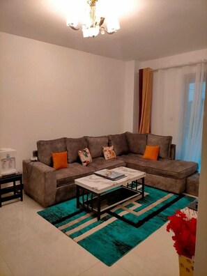 Deluxe Apartment | Living area | 24-inch Smart TV with satellite channels - Lux Suites Spring Garden Apartments (Nairobi)